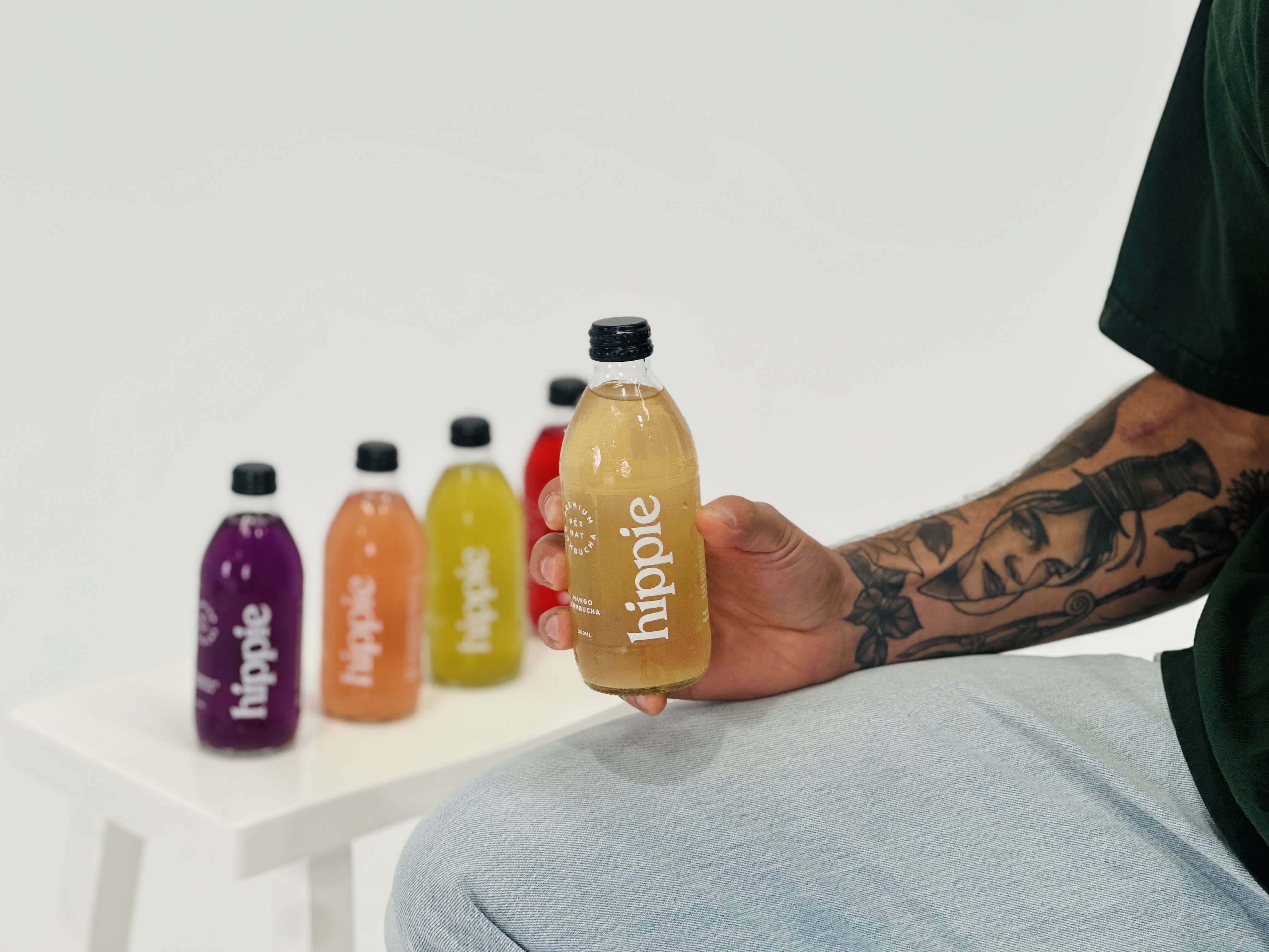 Hippie Kombucha bottles with a glass of naturally sparkling kombucha